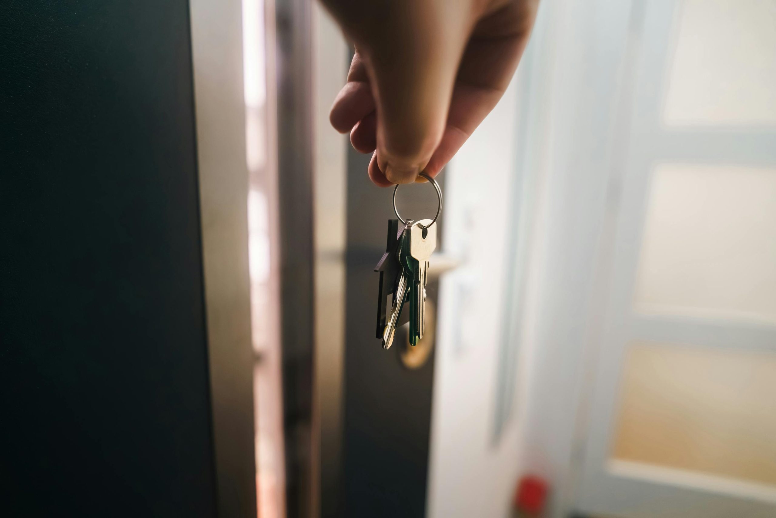 Llaves de casa colgando de la cerradura de una puerta de entrada